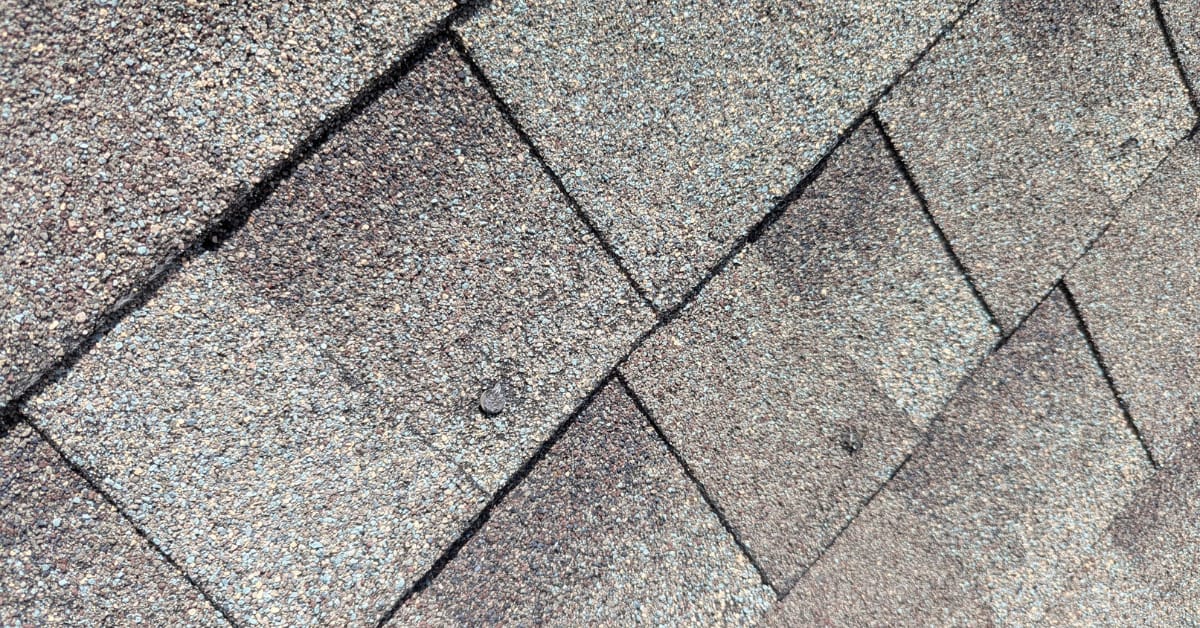 Residential roof replacement by DFW Roofers in Plano, Texas, highlighting damage in the shingles